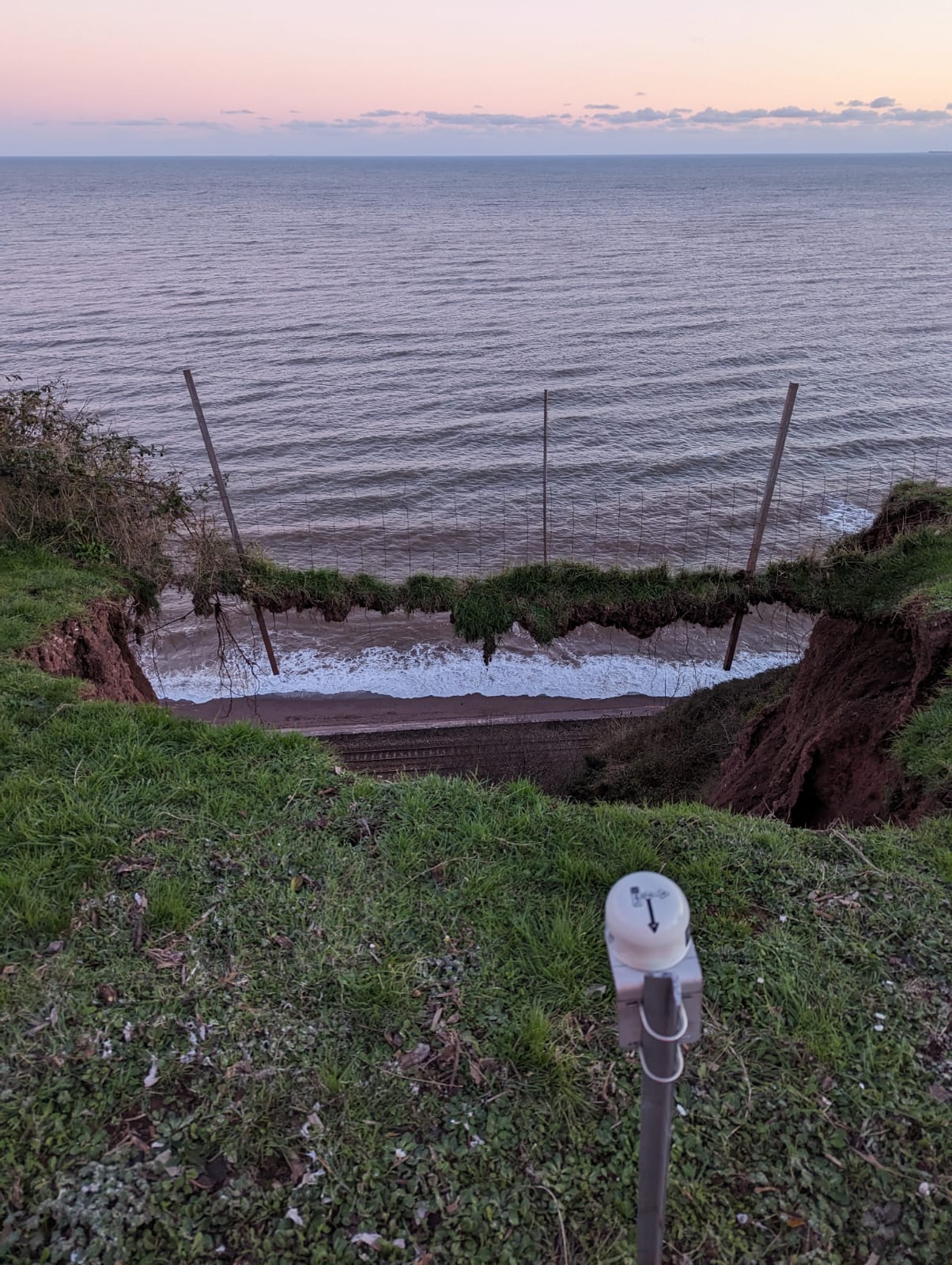 Image taken from the top of the cliff, showing the hole left by the slip and a tilt meter to monitor for further slips.